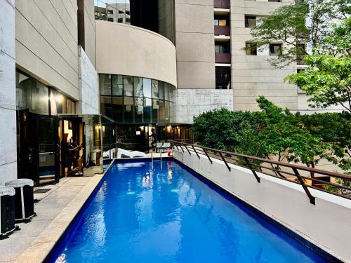 a large blue pool in front of a building at Hotel stay Itaim bibi in Sao Paulo