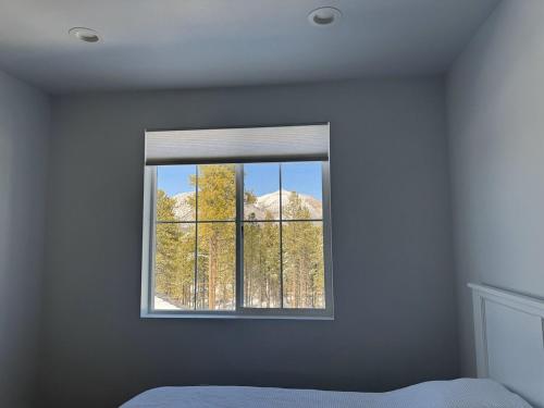 a bedroom with a window with a view of trees at Mountain Pines Getaway in Flagstaff