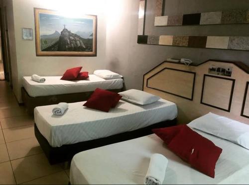 a hotel room with two beds with red pillows at Pousada Recanto do Brás in Sao Paulo