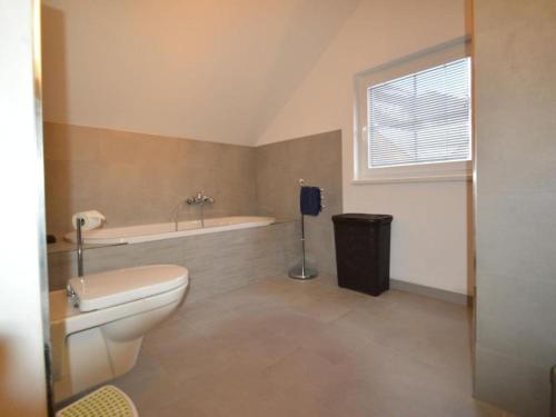a bathroom with a toilet and a bath tub at Ahorn in Staudach