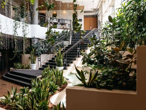 un vestíbulo con escaleras y macetas en Mercure Sydney Parramatta, en Sídney