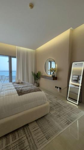 a bedroom with a large bed and a mirror at Luxury apartment with full sea view in Jeddah