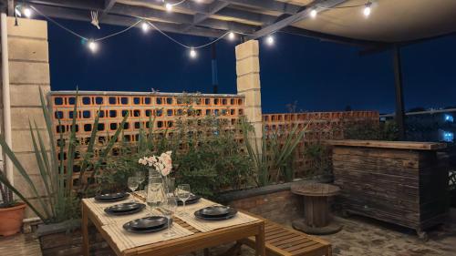 a patio with a table with plates and glasses at Casa Céntrica con Roof garden y Vistas a la Ciudad in Guadalajara