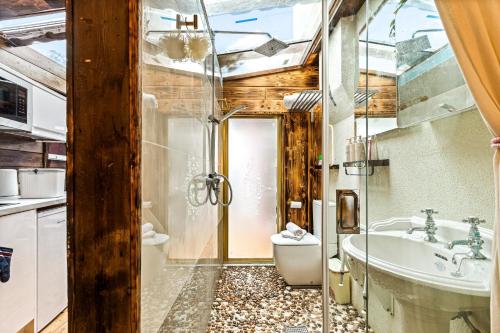 Un baño con bañera, inodoro y lavabo. en Guest suite with hot tub and sauna, en Redbridge