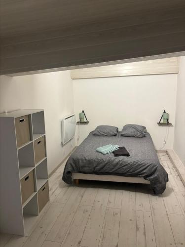 a bedroom with a bed and a white wall at TheNest in Vienne