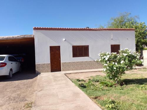 a white house with a car parked in front of it at Don Carmelo in Fiambala