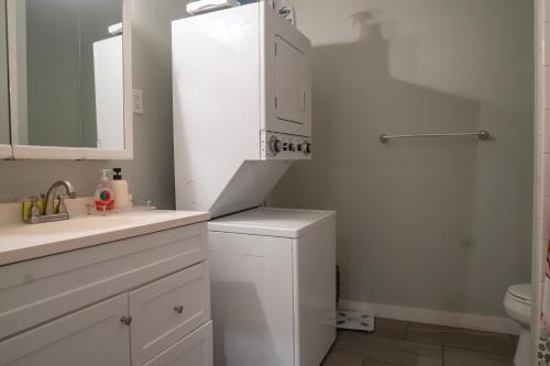 a white bathroom with a sink and a refrigerator at Centrally-Located Studio in DWTN Richmond in Richmond