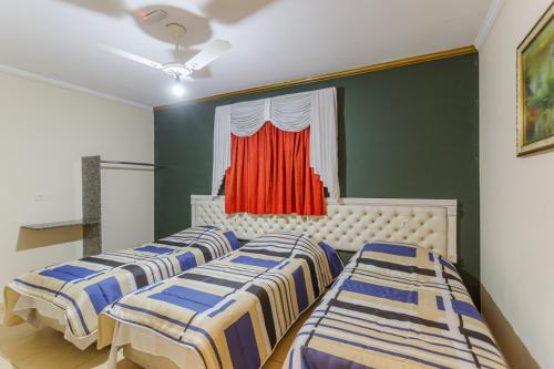 three beds in a room with a window at Hotel do Museu no ipiranga com TV ventilador banheiro in São Paulo