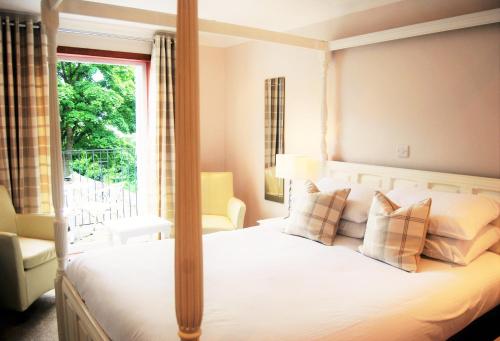 a bedroom with a canopy bed with a window at Kingswood Hotel in Burntisland