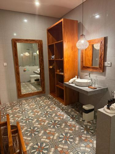 a bathroom with a sink and a mirror at Santai Suites Nusa Dua in Nusa Dua