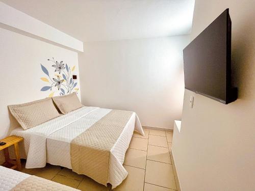 a bedroom with a bed and a tv on the wall at Pousada Solana in Salvador
