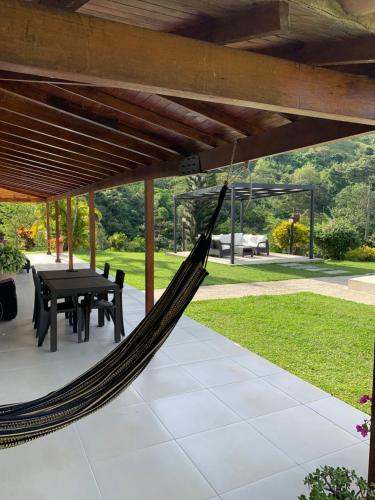 a hammock on a patio with a table and chairs at La Miel in Barbosa
