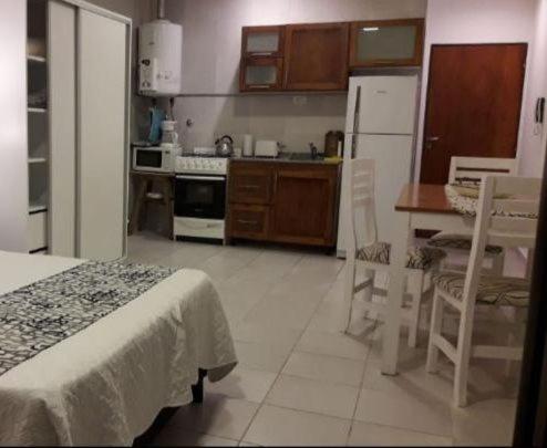 a kitchen with a table and chairs and a refrigerator at Paraná Suite Alem in Paraná