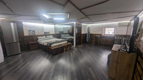 Großes Zimmer mit einem Bett und Holzböden. in der Unterkunft Смарт квартира в стилі лофт в самому центрі міста in Sumy
