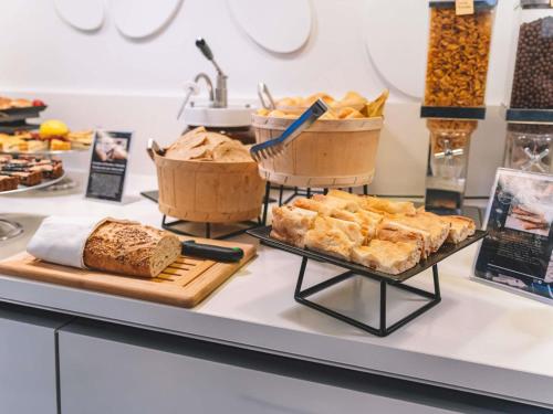 a buffet with bread and pastries on a counter at Mercure Roma Centro Colosseo in Rome