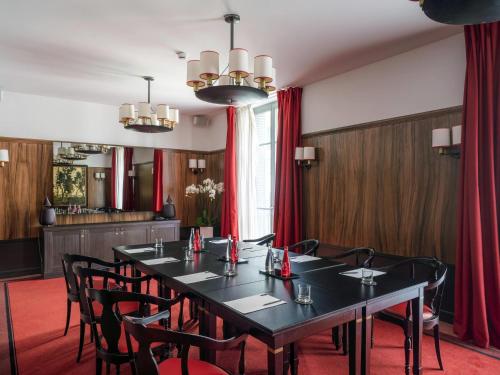 a conference room with a black table and chairs at Carlton Hotel Lyon - MGallery Collection in Lyon