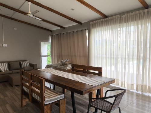 a living room with a wooden table and chairs at Quincho El Solar in Corrientes