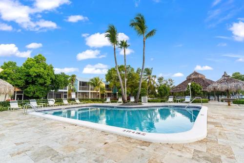 a pool at a resort with chairs and palm trees at Saltwater Lagoon Front View, Marina, Kayaks in Key Largo