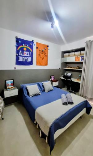 a bedroom with a bed and a desk in it at Quarto Vista Mar in Recife