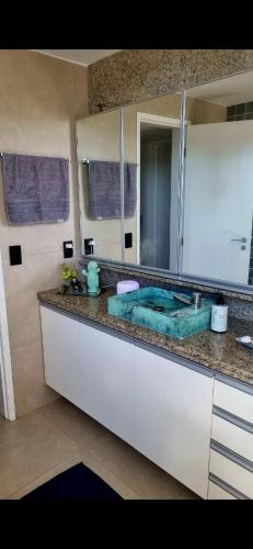 a bathroom with a sink and a large mirror at Quarto Vista Mar in Recife