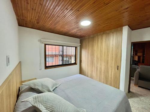a bedroom with a bed with a wooden ceiling at New apart steps from CC Mayorca in Sabaneta
