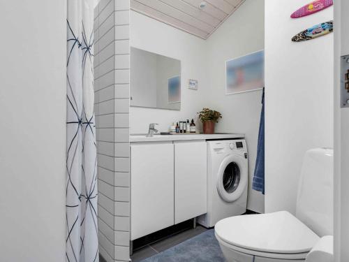a white bathroom with a washing machine and a washer at 5 star holiday home in Karrebæksminde in Karrebæksminde