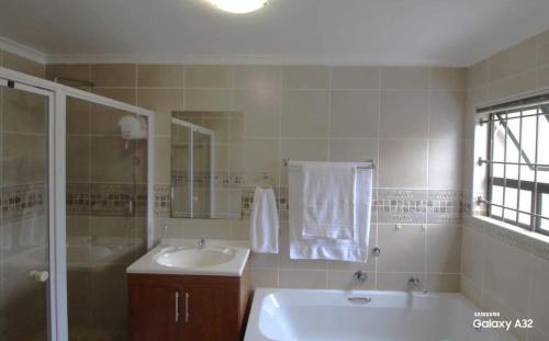 a bathroom with a tub and a sink and a shower at 87 on Sunbird in Langebaan