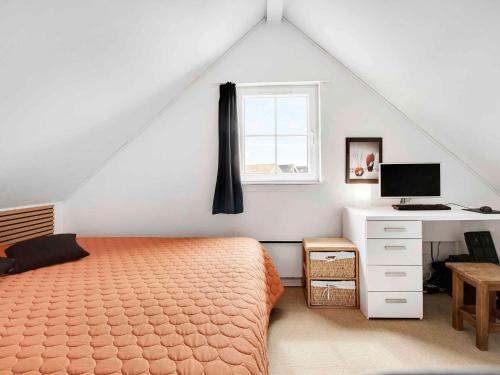 a bedroom with a bed and a desk and a window at 5 star holiday home in Brenderup Fyn in Åbjerg