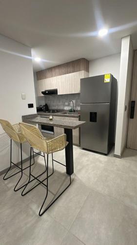 una cucina con tavolo, sedie e frigorifero di Apartamento nuevo a Villavicencio