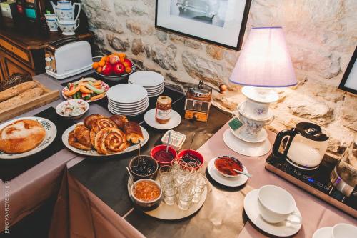 a table topped with dishes of food and a lamp at Domaine de la Pommeraye & Spa in La Pommeraye