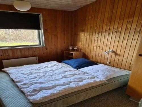 a bedroom with a bed in a wooden wall at 5 star holiday home in Ørsted in Udbyhøj