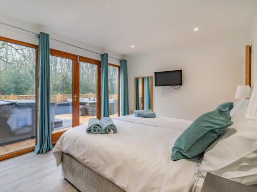 a bedroom with a large bed with a tv and windows at Waterside Lodge in Elland
