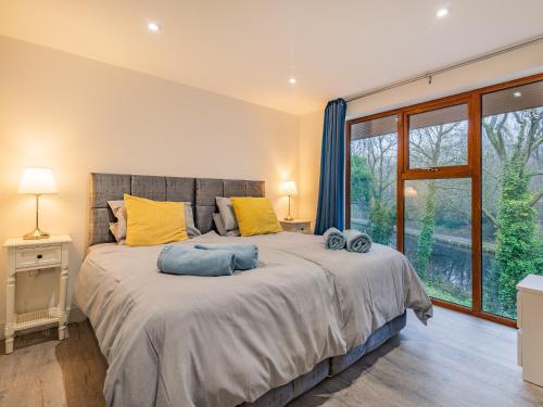 a bedroom with a large bed with yellow and blue pillows at Waterside Lodge in Elland