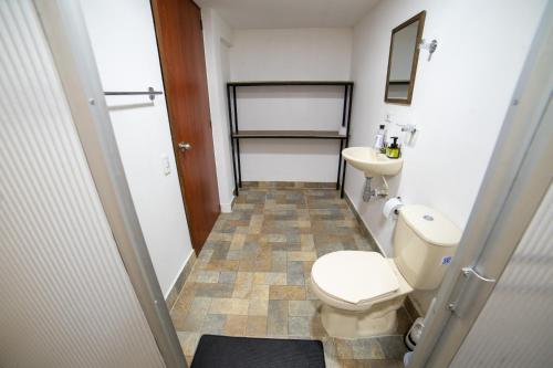 a small bathroom with a toilet and a sink at Calle Real House in Salento