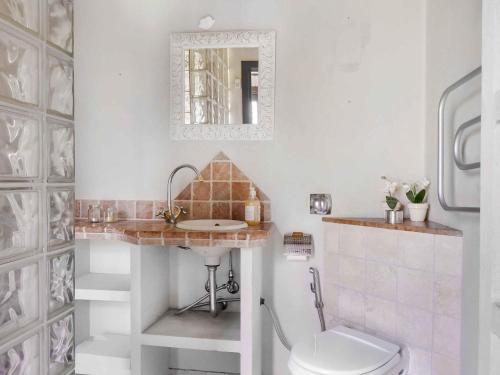 a bathroom with a toilet and a sink and a mirror at 5 star holiday home in Nykøbing Sj in Nyrup