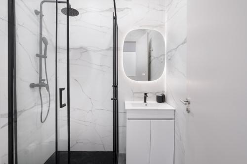 ein weißes Badezimmer mit Waschbecken und Spiegel in der Unterkunft Villa with Private Pool, BBQ & Patio in Vila Nova de Gaia