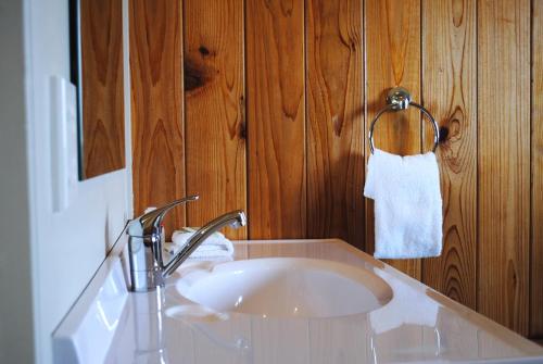 a white sink in a bathroom with wooden walls at Kings Ohakune in Ohakune