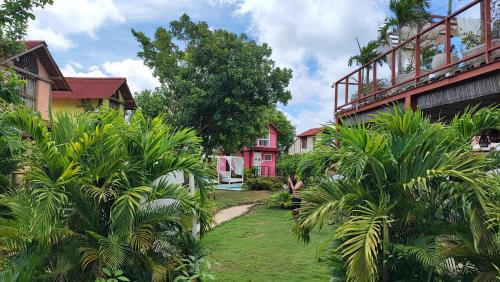 a garden with palm trees in front of houses at Tiny Village Cartagena Boutique Resort in Tierra Bomba