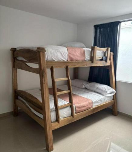two bunk beds in a room with a window at posada la hermosa in Santa Rosa de Cabal