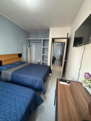 a hotel room with two beds and a table at Aluna Beach - Playa Miramar in Ciudad Madero