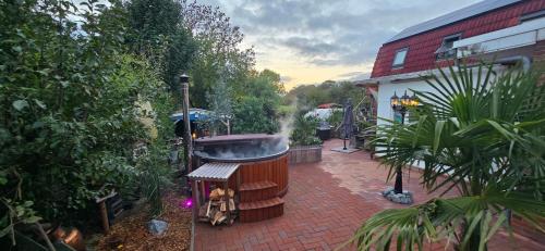 a hot tub on a brick patio next to a building at Monteurs-Ferienwohnung in Emden