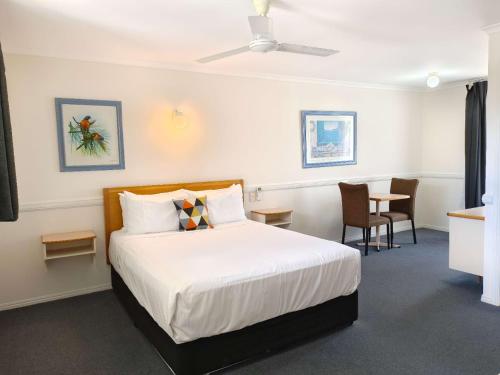 a hotel room with a bed and a table at Best Western Ambassador Motor Lodge in Hervey Bay