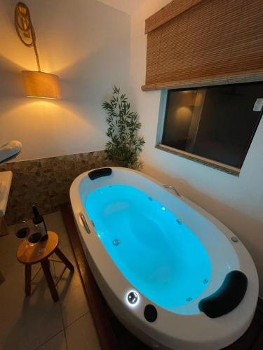 a bath tub in a bathroom with a blue light at Quase um Spa in Petrópolis