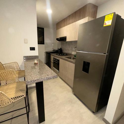 una cucina con frigorifero in acciaio inox e tavolo di Apartamento nuevo a Villavicencio