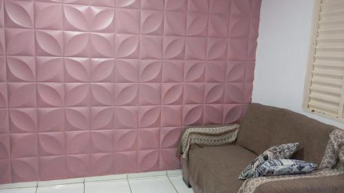 una sala de estar con una pared rosa en Casa de temporada nos fundos, en Foz do Iguaçu