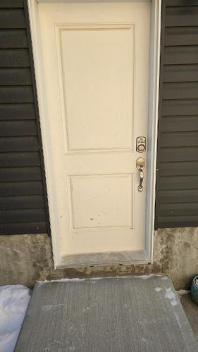 エドモントンにあるSelf contain suite Edmonton NWの家の前にマットが敷かれた白いドア