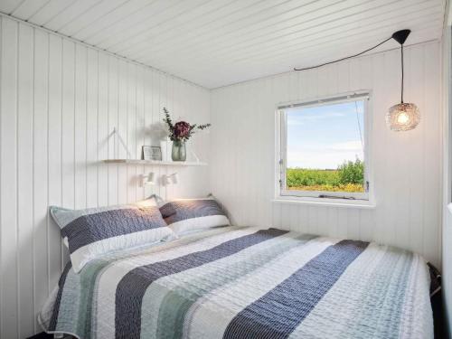 a white bedroom with a bed and a window at 5 star holiday home in Karrebæksminde in Karrebæksminde
