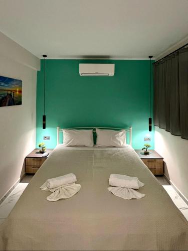 a bedroom with a large bed with a green wall at Margaret House in Zakynthos