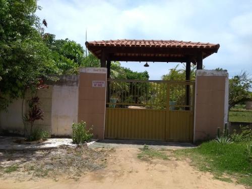 a gate with a fence and a gate with a roof at Pousadinha Mangabeiras II in São Mateus