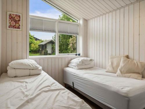 two beds in a room with a window at 5 star holiday home in Strøby in Strøby Ladeplads